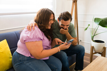 Obraz premium Cheerful boyfriend and girlfriend looking excited laughing
