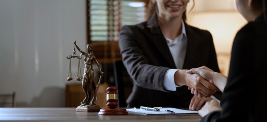 Businesswoman shaking hands to make a deal with her partner lawyers or attorneys discussing a...