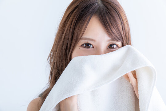タオルで顔を隠す女性　Woman hiding her face with a towel