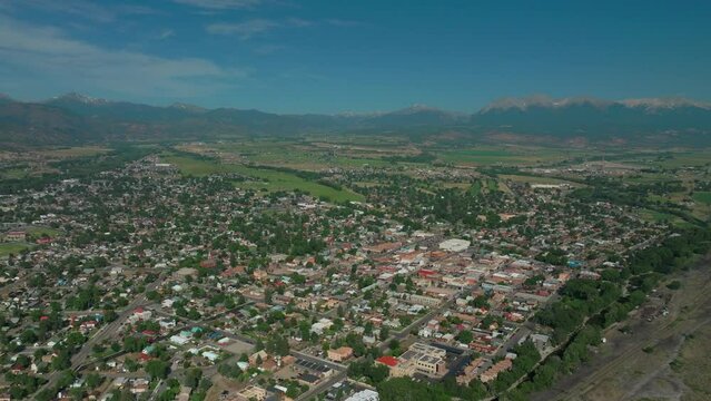 Aerial cinematic drone mid summer downtown Salida Colorado near Buena Vista on Arkansas River Riverside Park Scout surfing wave biking hiking rafting Rocky Mountain up high up backward movement