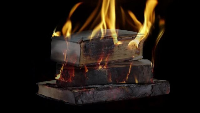 Stack of books burning on black background