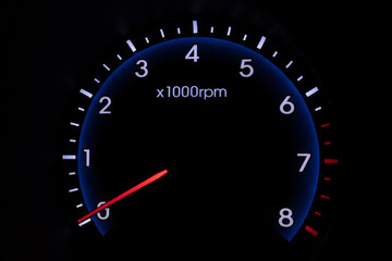 Tachometer on car with dark black background