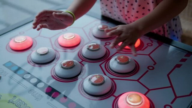 Toddler Girl Strike the Lighted Buttons As Fast As Possible Playing on Naughty Beans Arcade Machine