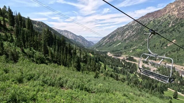 Mountain ski lift tram over summer forest valley Utah. Summer winter season mountain resort. Vacation nature family fun destination. Peaks nature landscape forests. Rocky Mountain Salt Lake City Utah.