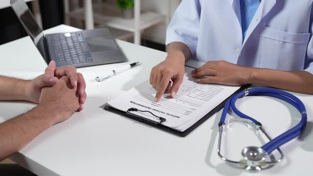 The doctor explains the patient in a consultation. Describe the patient's symptoms or ask questions while they discuss the documents together in a treatment plan.