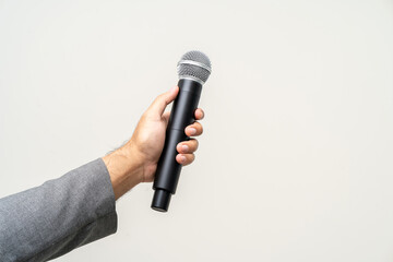 Close up businessman speaker hand holding High quality dynamic microphone and singing song or speaking talking with people on isolated white background. Male testing microphone voice for interview