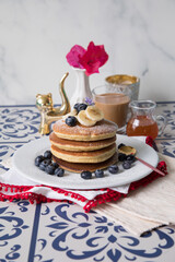 Pancakes stack with banana and blueberries topping and bee honey breakfast food