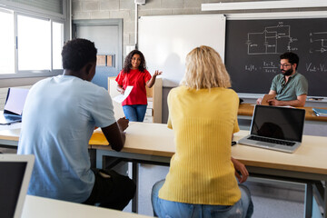 African American teen female high school student giving oral class presentation in front of...