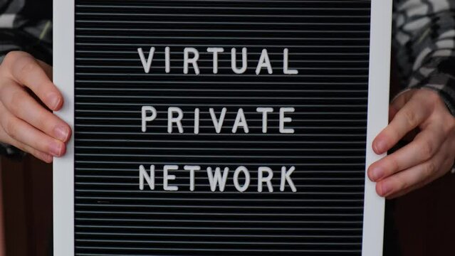 Female hand holding Letter board with text of VIRTUAL PRIVATE NETWORK VPN creation Internet protocols for protection private network anonymous safe and secure internet access on gadgets. Future