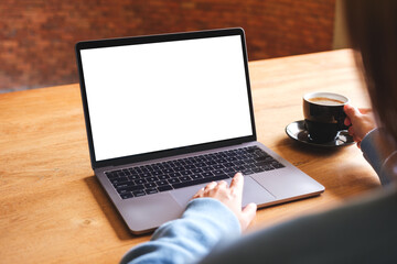 Mockup image of a woman using and working on laptop computer with blank white desktop screen while drinking coffee