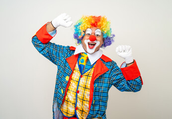Laughing Mr Clown. Portrait of Funny happy face comedian Clown man in colorful costume wearing wig...