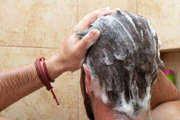 young man washing head hair with shampoo in the shower, male personal hygiene bathroom routine,...