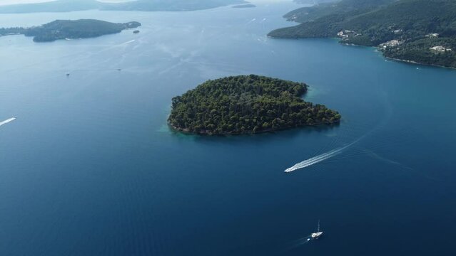 Aerial drone video view with panning motion of motor boats sailing near a small island in Nydri or Nidri Lefkada Greece