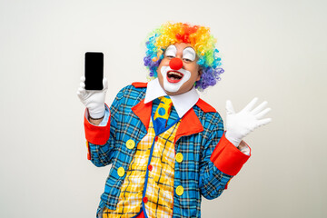 Mr Clown. Portrait of Funny face Clown man in colorful uniform standing holding smartphone. Happy expression male bozo in various pose with cellphone on isolated background.