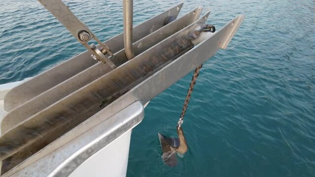 Close-up of the anchor chain retracting on a yacht. Raising the anchor on a yacht, a winch unwinds an iron chain with an anchor, a marked chain waiting for the anchor to be raised