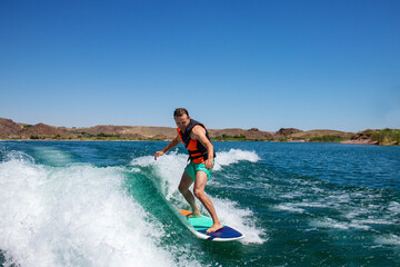 a man on a surfboard. a guy on a wave on a wakeboard