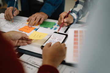 ui designer brainstorming about mobile app interface wireframe design with customer breif and color code at office.