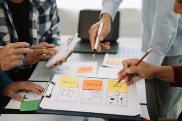 ui designer brainstorming about mobile app interface wireframe design with customer breif and color code at office.