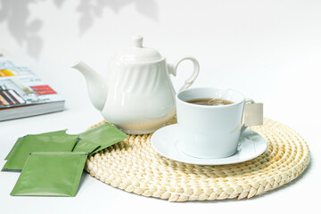 Cup of herbal tea on wicker coaster