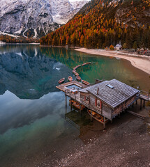 Lake Braies, Italy - Aerial view of Lake Braies (Lago di Braies) in the Italian Dolomites at South Tyrol with wooden boats, wooden cabin and Seekofel Mountain reflecting in the lake at autumn