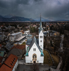 Bled, Slovenia - Aerial panoramic view of St. Martin's Parish Church with Julian Alps at the background on a cloudy winter afternoon