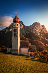 Seis am Schlern, Italy - St. Valentin Church and famous Mount Sciliar in the Italian Dolomites with blue sky and warm sunlight at South Tyrol on an autumn afternoon