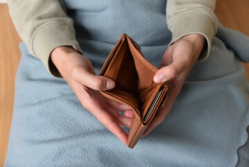 Eine Frau zeigt ihre leere Geldbörse