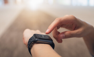Close up of hand touching smartwatch with heart rate checking app on the screen.