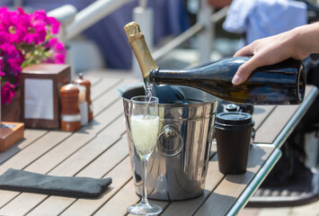 The waiter pours a glass of champagne