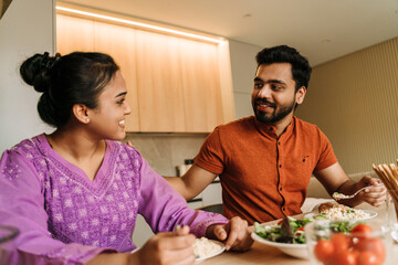 Young indian couple talking while having lunch together