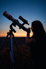 Astronomer looking at night sky with a telescope.