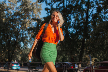 Happy middle aged woman outside in city with mobile phone