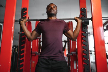 Handsome young African American man working out at the gym