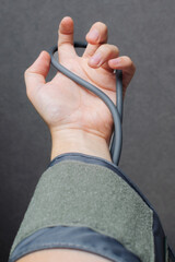 Man holds Blood Pressure Cuff in his hand and arm is in tension. Concept of poor health, High and Low Blood Pressure, healthcare, medicine and hope. Vertical photo