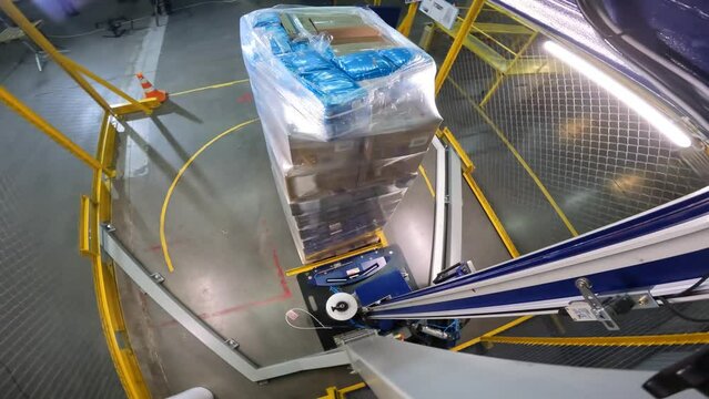 Box stretch wrapping machine. pallet wrapping machine. Machine for wrapping boxes in a plastic film in a circle. Packing boxes in plastic film.