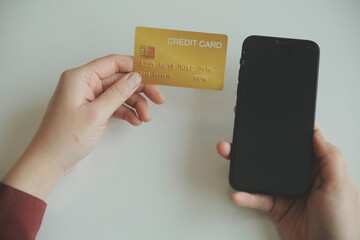Woman hands holding and using cradit card for shopping online.