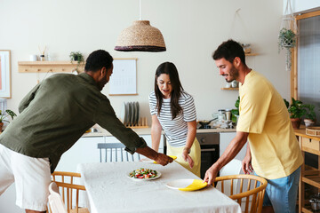 Family setting table for lunch in kitchen