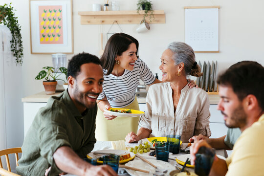 Happy family spending leisure time having lunch at dining table in kitchen