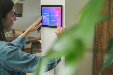 Young woman with tablet with smart home control functions