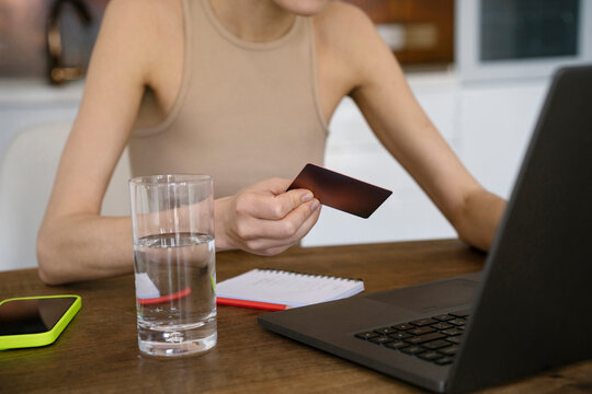 Freelancer using credit card for online payment on laptop at home