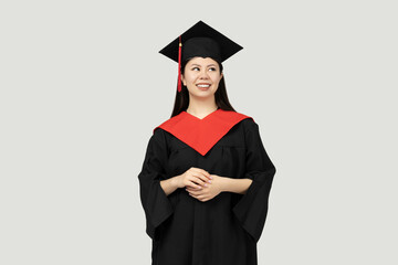 A girl of Asian appearance, a college graduate, on a gray background