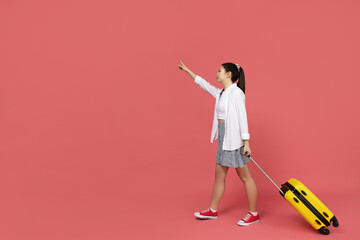An Asian girl is going on a trip, with a yellow suitcase
