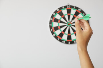 Target, dartboard, hitting the center. On a light background, with a wire in his hand.