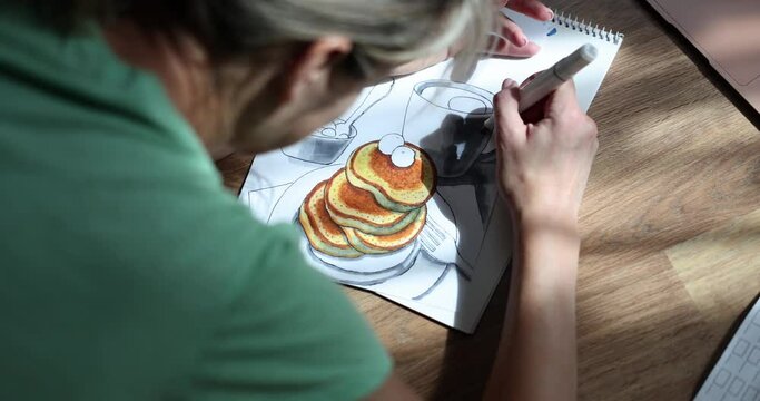Woman draws in food album with pencil at home. Meditative drawing techniques concept