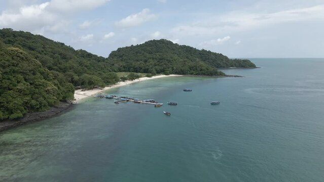 Tourists arrive at pier on Pulau Beras Basah, Malaysia, by tour boat
