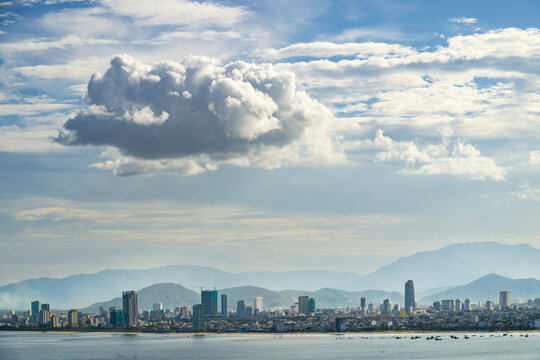 Distant view of a coastal city under clouds with mountains in the distance at Da Nang in Vietnam