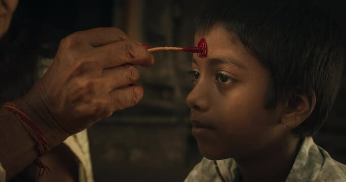 Authentic Footage of Hindu Priest Putting a Tilaka on Male Kid in a Temple. Senior Guru Giving Blessings with a Mark on the Forehead to a Child, Faithful Worshipers in Religious Ceremony