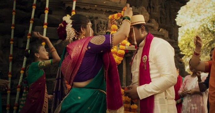 Slow Motion Authentic Footage of Traditional Indian Wedding Customs: Groom and Bride Being Celebrated by Happy Friends and Family Throwing Flowers, Singing, Witnessing a Union Built on Love  