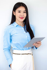 Asian businesswoman smiling and holding digital tablet standing on white background. Happy business woman using  tablet on copy space light background. Business,finance, employment,female successful..