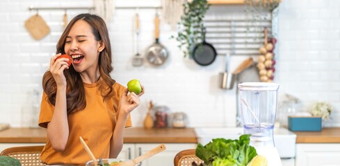 Portrait of beauty body slim healthy asian woman big smile cooking and preparing vegan food healthy holding apple, green apple, dental, teeth, fruit in kitchen at home.Diet.Fitness, healthy food